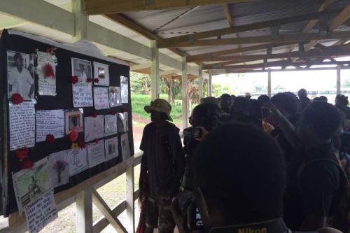PHOTO: Bougainville residents looking at public posters of missing people in the town of Arawa. (Supplied: Omarsharif Ghyasy/ICRC)