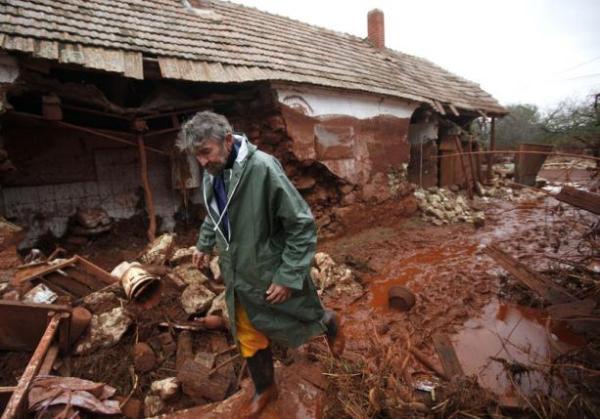 A man walks next to his destroyed house in the flooded village of Kolontar, Hungary October 6, 2010. REUTERS/Laszlo Balogh